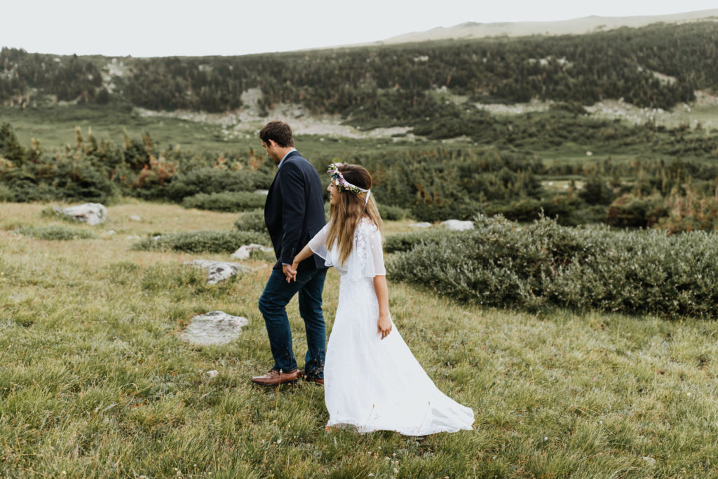 Couple walking through an alpine meadow.